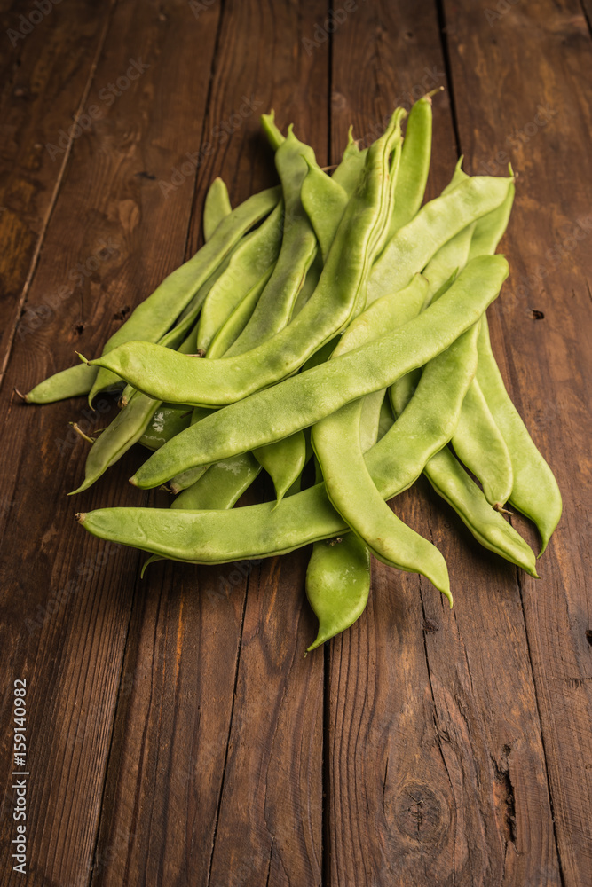 A pile of fresh green beans on table. Green runner beans. Top view A pile of fresh green beans on table. Green runner beans. Top view