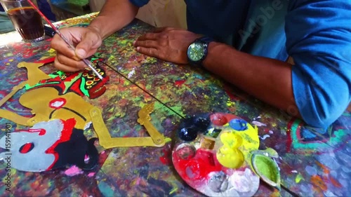 Painting a traditional wajang puppet in Indonesia photo