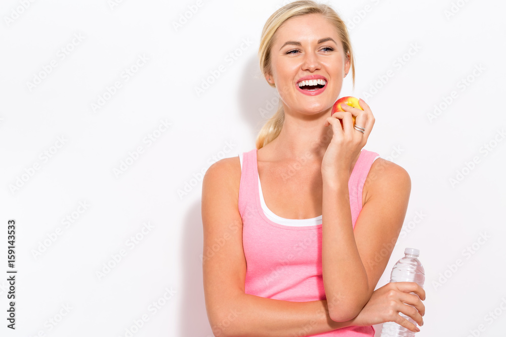 Happy young woman holding apple and water Happy young woman holding apple and water
