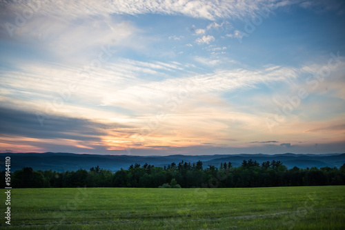 Beautiful Sunset over Meadow with Mountain View 