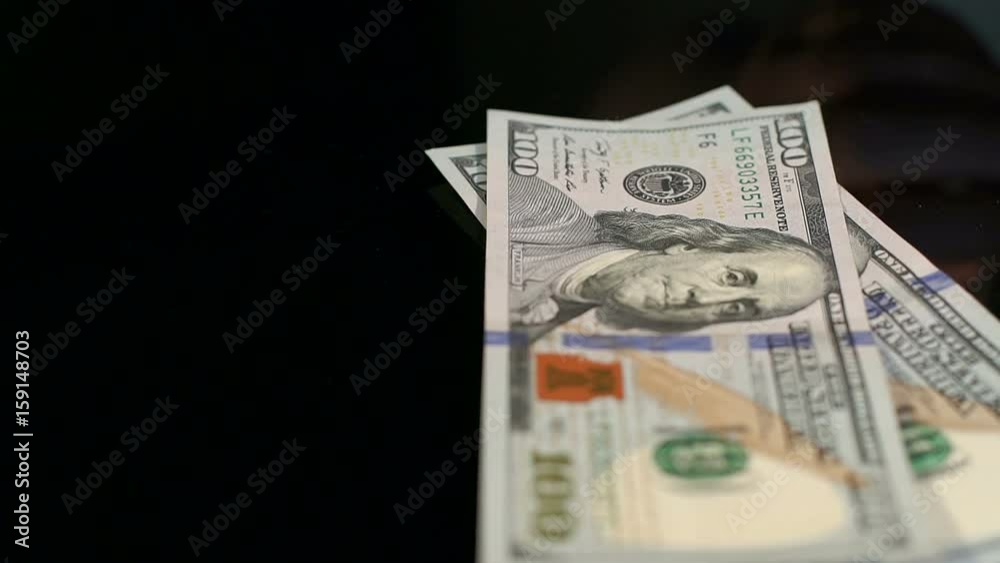 Woman throws on the table 100 dollar bills. Considers money isolated on black background. Woman throws on the table 100 dollar bills. Considers money isolated on black background.