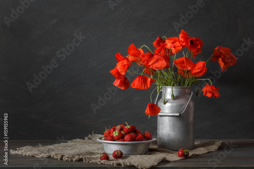 Fototapeta Naklejka Na Ścianę i Meble -  Still life in a rustic style: aluminum cookware, bouquet of red poppies and strawberry on a wooden table.