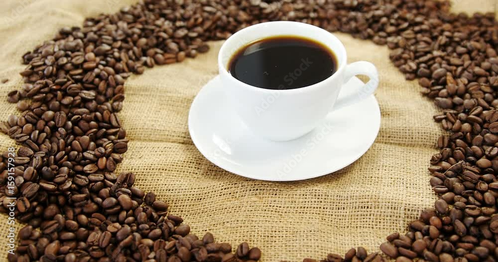 Cup of coffee surrounded with roasted beans Cup of coffee surrounded with roasted beans
