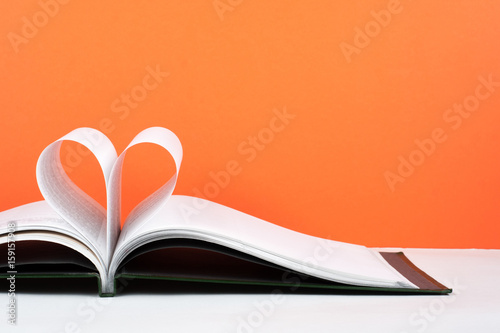 Old open hardback book, page decorate into a heart shape for love in Valentine's. love with open book heart. photo