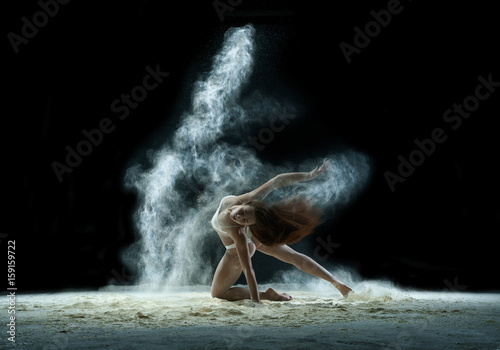 Girl in a cloud of white dust studio portrait