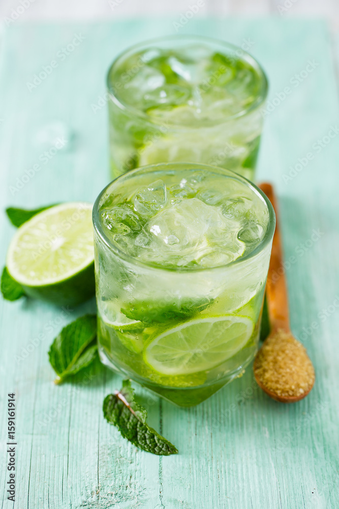 Mojito and ingredients on turquoise wooden surface Mojito and ingredients on turquoise wooden surface