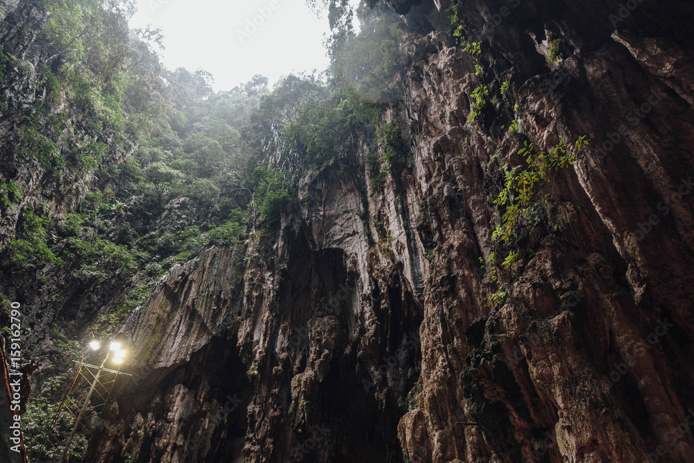 Limestone cave texture with green and sun light inside Batu Caves near Kuala Lumpur, Malaysia