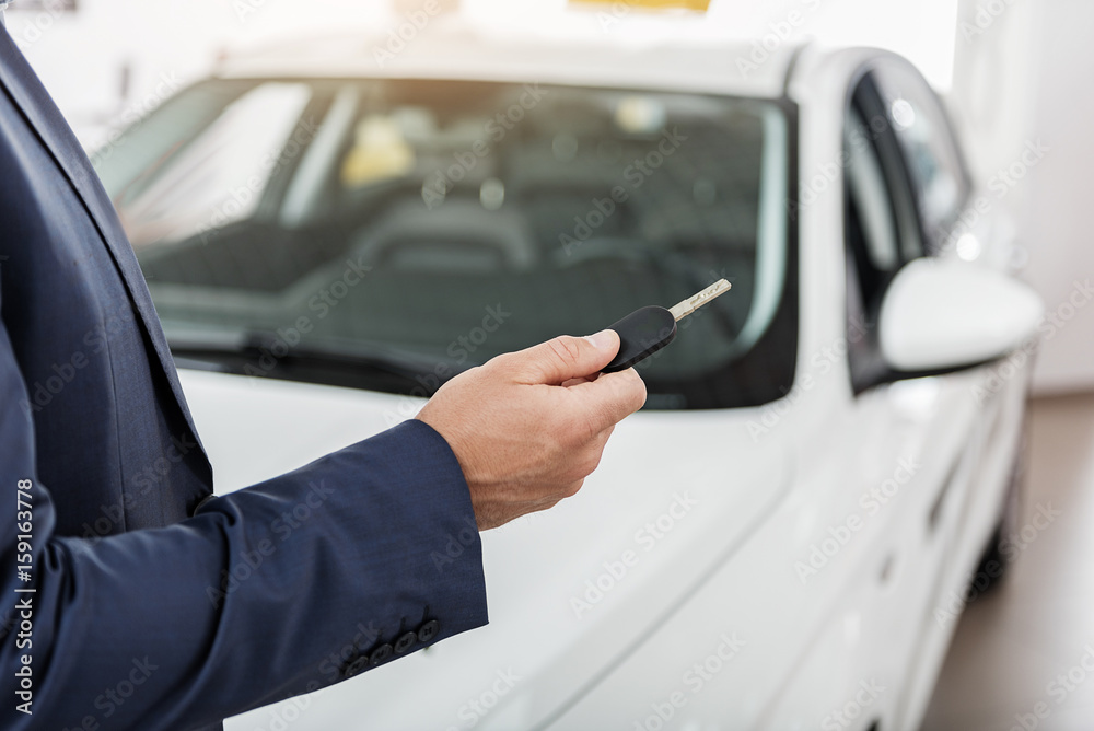 Man arm holding automobile clef in showroom Man arm holding automobile clef in showroom