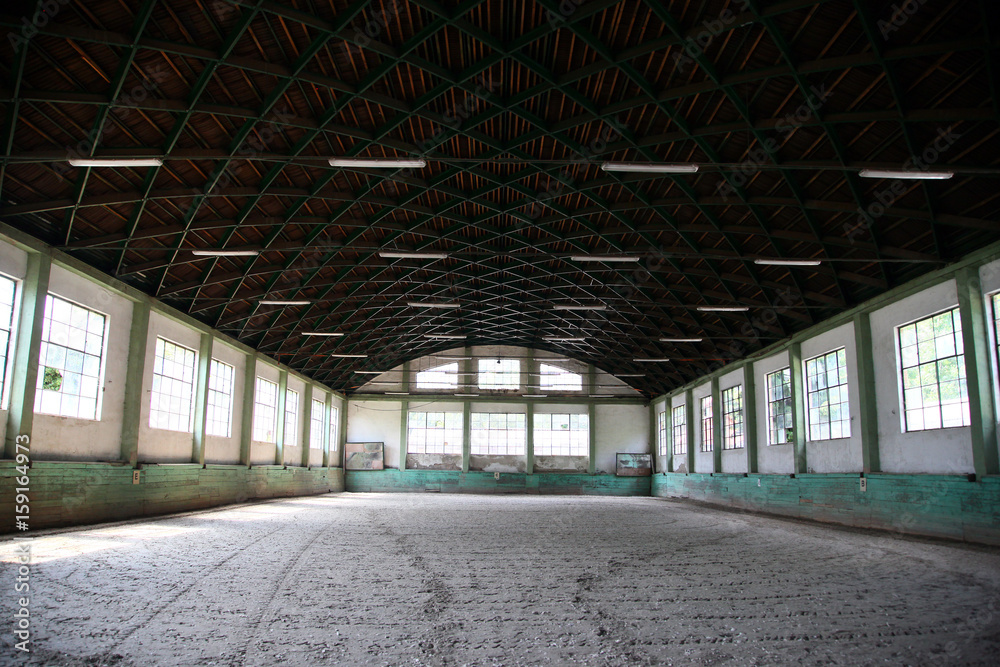 Abandoned riding hall without horses and horsemen