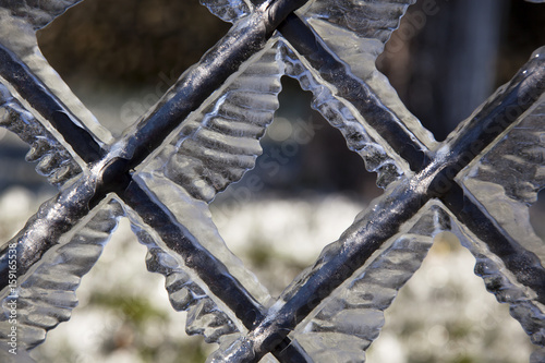 Formazioni di ghiaccio su inferriata metallica photo