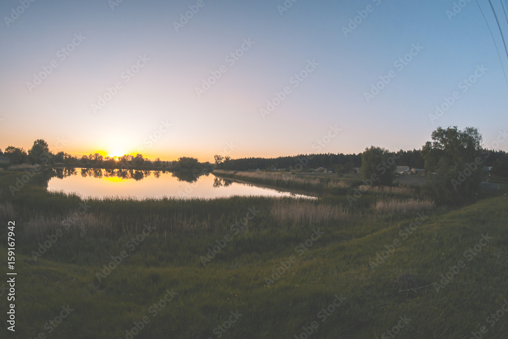 Evening summer landscape on a pond at sunset of the day.