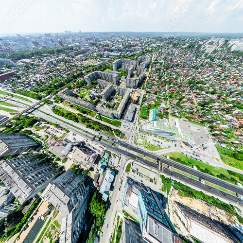 Aerial city view with crossroads and roads, houses, buildings, parks and parking lots, bridges. Helicopter drone shot. Wide Panoramic image. © mr.markin