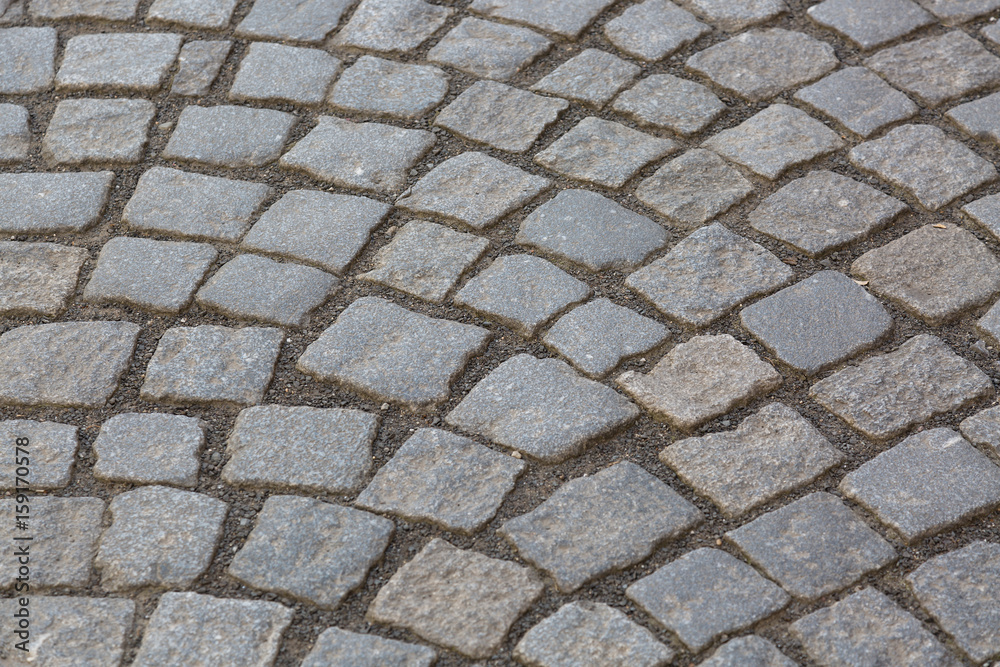 Granite cobblestoned pavement background. Stone pavement texture. Abstract background of old cobblestone pavement close-up in Prague Granite cobblestoned pavement background. Stone pavement texture. Abstract background of old cobblestone pavement close-up in Prague