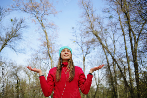 Smiling yoga sports girl with closed eyes, on a forest background