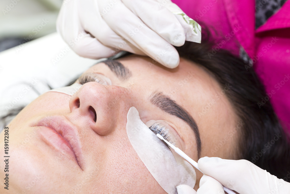Woman on the procedure for eyelash extensions, eyelashes lamination Woman on the procedure for eyelash extensions, eyelashes lamination