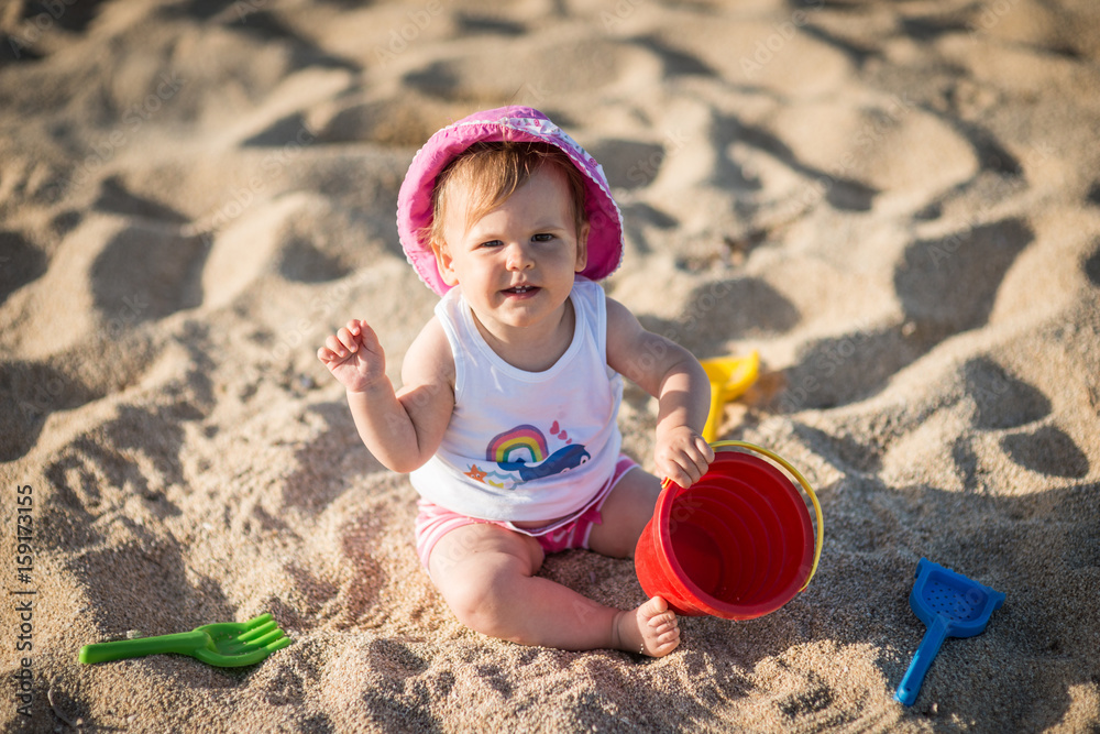 Little girl playing with bach toys in sand Little girl playing with bach toys in sand