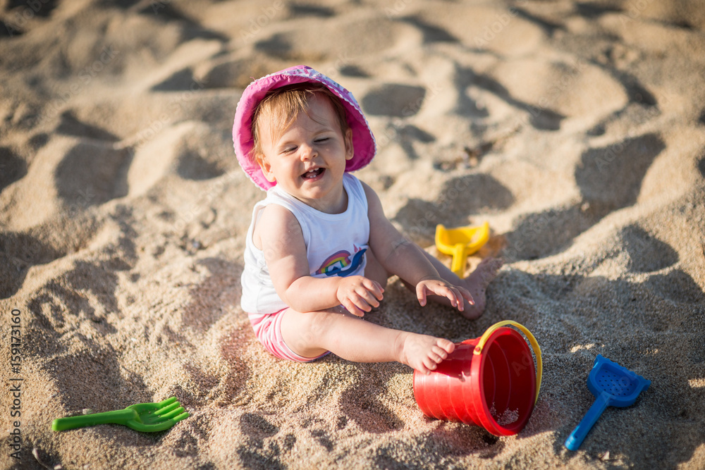 Little girl playing with bach toys in sand Little girl playing with bach toys in sand