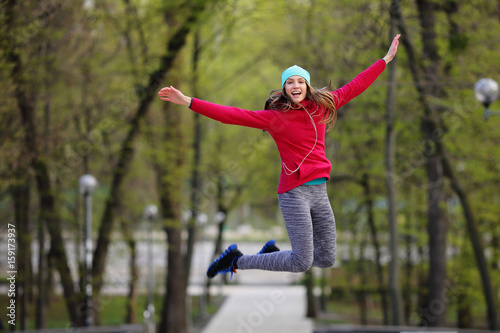 Sport bright woman jumping in park, happy, screaming