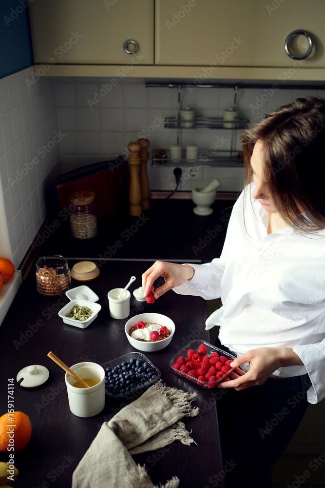 Woman preparing breakfast berris and granola , healthy lifestyle Woman preparing breakfast berris and granola , healthy lifestyle