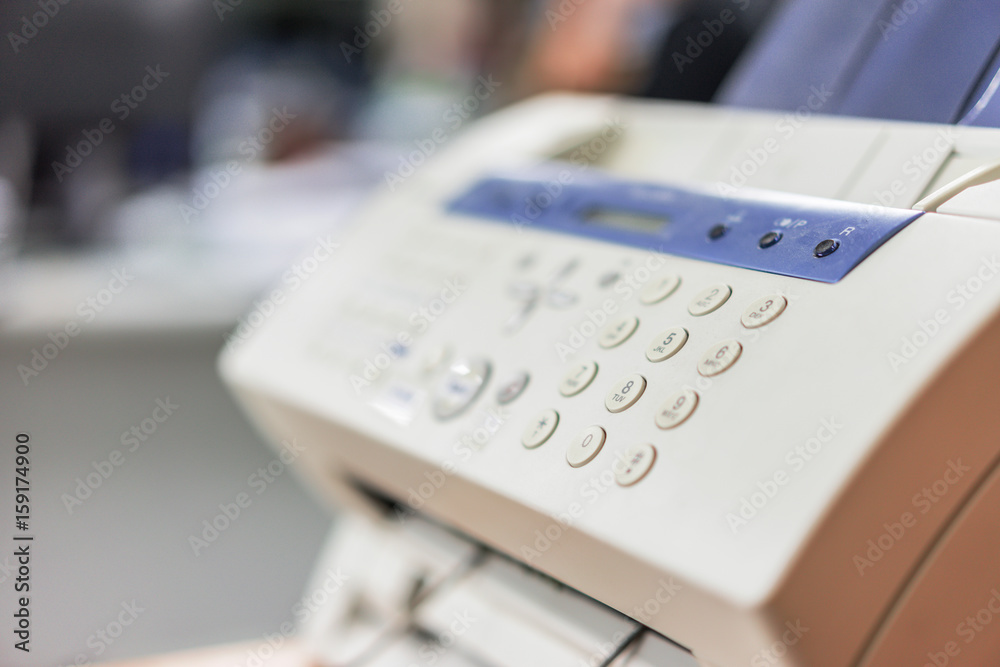A fax machine is placed on the office desk. A fax machine is placed on the office desk.