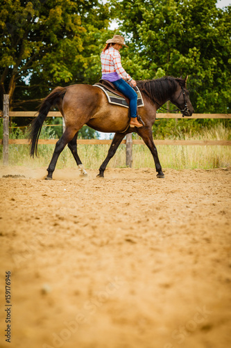 Cowgirl doing horse riding on countryside meadow © Voyagerix