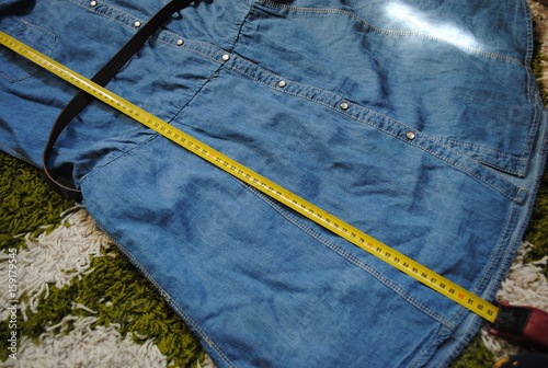 Smiling girl seller taking measurement of cloth at drapery shop photo