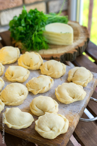 Dumplings raw on a wooden board. Russian and Ukraine national food. The process of cooking dumplings.