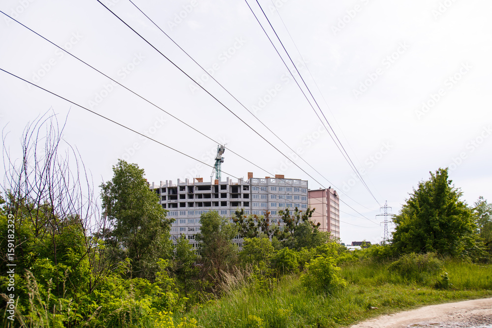 Construction of new house or building. General view. Unfinished cement building in the summer. The introduction of urbanization into nature. Capital construction in Ukraine