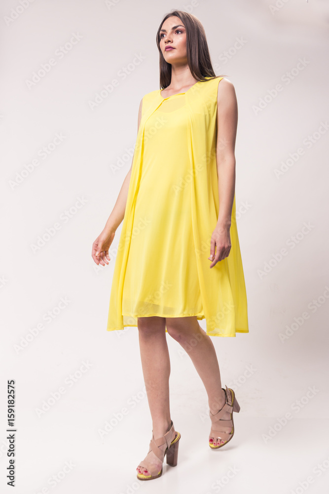 one young Caucasian woman, studio, white background, yellow dress, high heel shoes, fashionable one young Caucasian woman, studio, white background, yellow dress, high heel shoes, fashionable