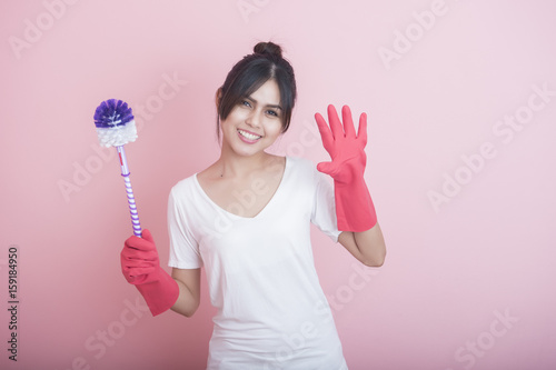 Beautiful asian housewife smiling on pink background
