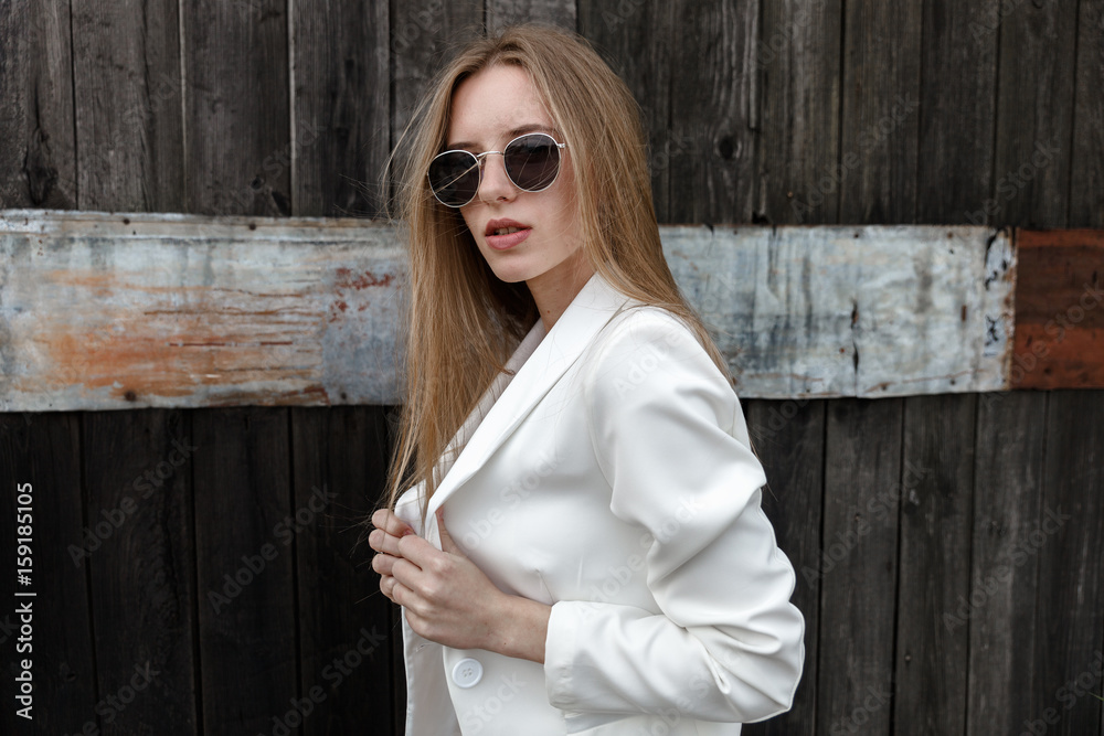 Obraz premium The sexy girl in white trousers about wooden wall