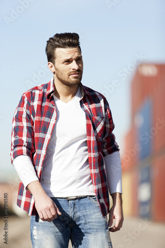 Handsome young man in white t shirt,shirt and jeans outdoors