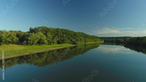 Aerial video of a quiet river and blue sky reflecting in it 