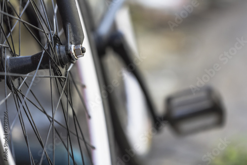 Close-up shot of front wheel of a bicycle with bokeh background.