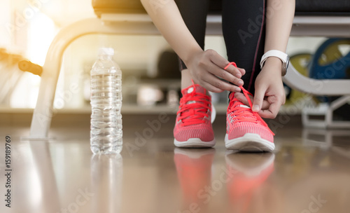 woman runner tying her shoelaces fitness exercise in gym
