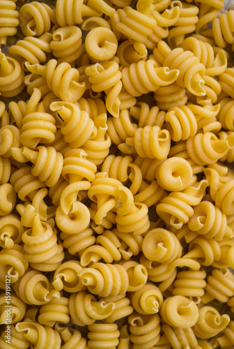 Pasta from hard wheat varieties, scattered on the table.