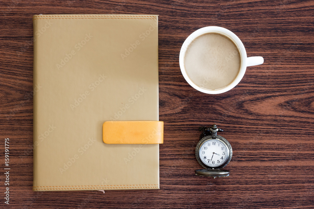 Notebook clook and cup of coffee on the desk. Notebook clook and cup of coffee on the desk.