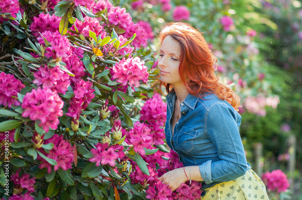 Young woman at a garden full of flowers Young woman at a garden full of flowers