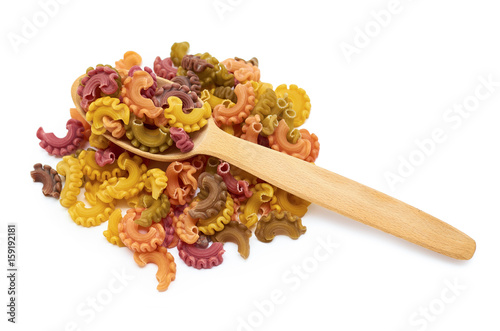 background of raw colored macaroni in the wooden spoon. Isolated on white background photo