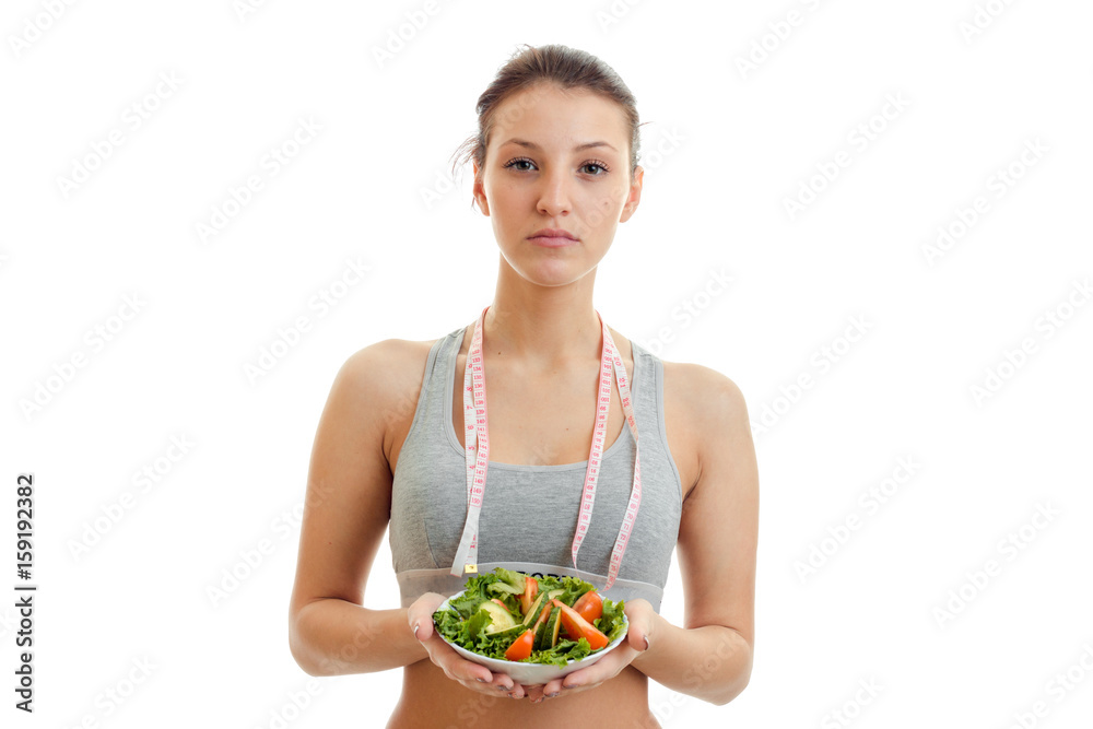 beautiful woman with measure tape on her neck eats salad beautiful woman with measure tape on her neck eats salad