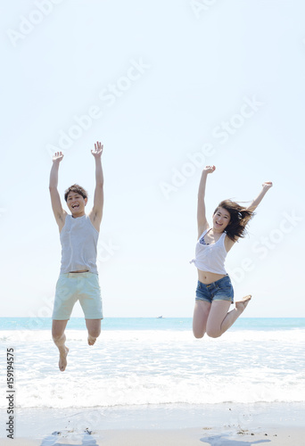 ビーチでジャンプするカップル