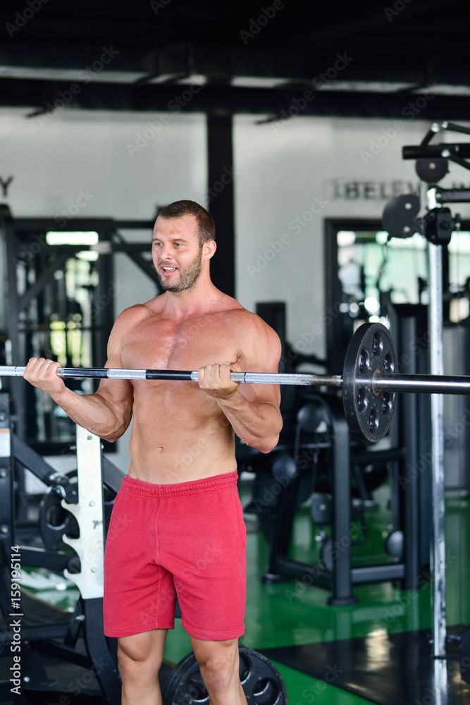 Man at the gym. Man makes exercises with barbell Man at the gym. Man makes exercises with barbell
