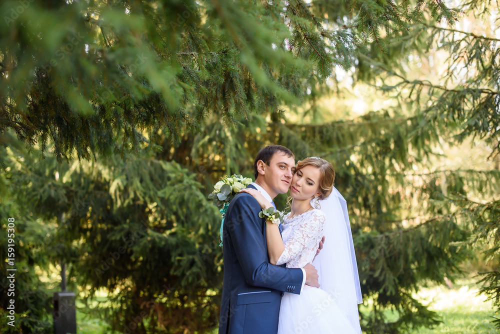 happy bride and groom at a park on their wedding day happy bride and groom at a park on their wedding day