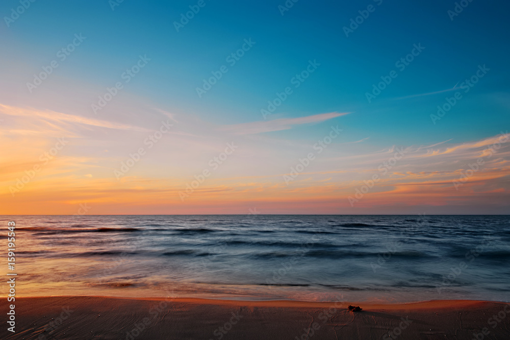 Beautiful twilight at Baltic sea beach. Waves blurred by long exposure. Gdansk Bay, Pomerania, Poland.