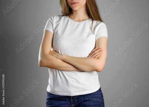 Woman in blank white t-shirt. The girl folded his hands on his chest. Isolated