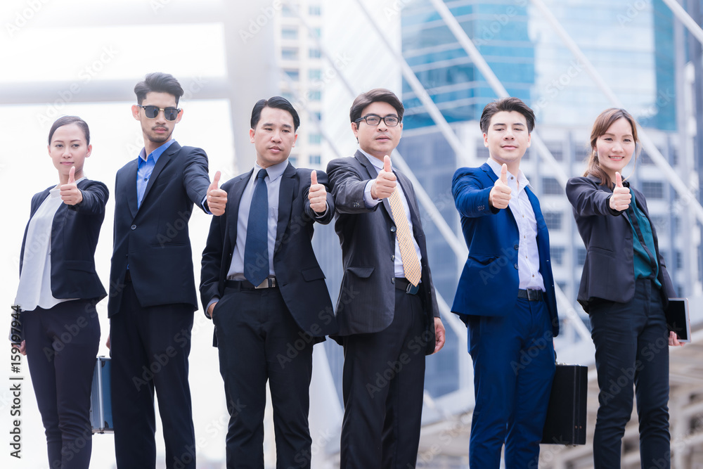 Successful business people with thumbs up and smiling Successful business people with thumbs up and smiling
