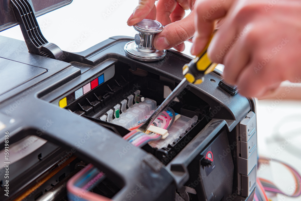 Repairman repairing broken color printer Repairman repairing broken color printer