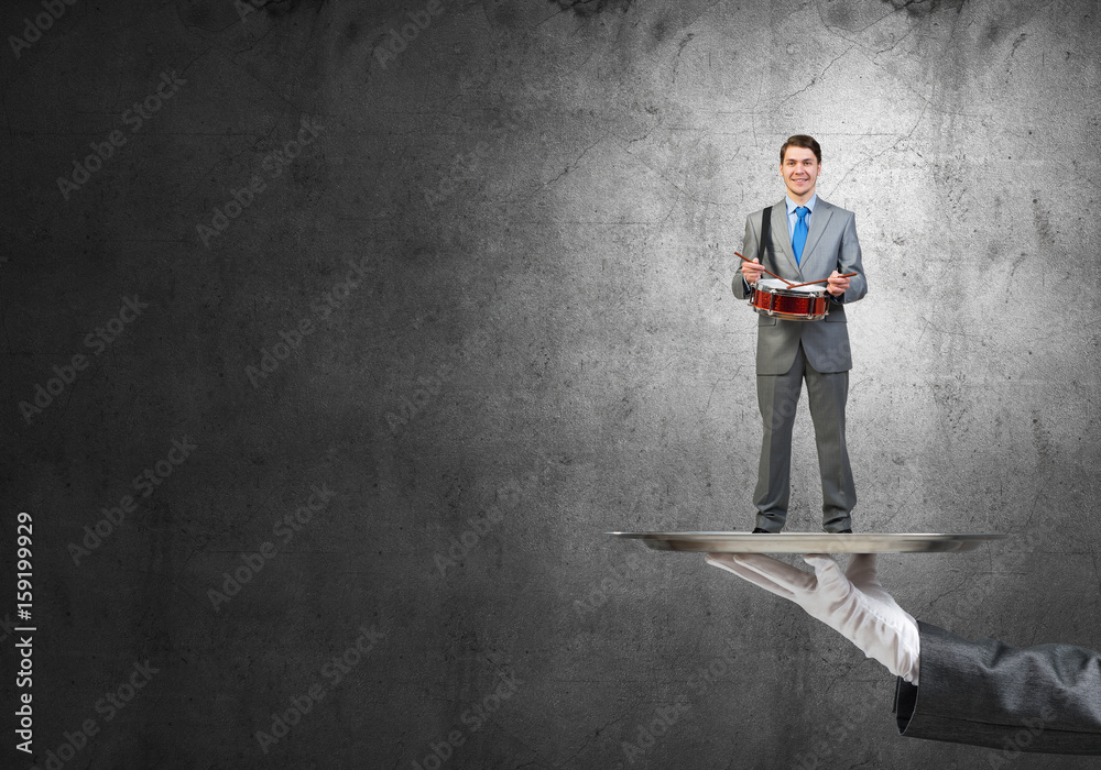 Businessman on metal tray with red book in hands against concrete background Businessman on metal tray with red book in hands against concrete background