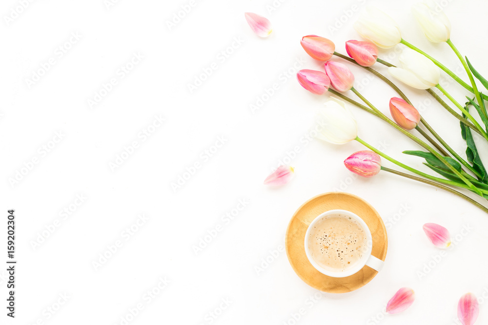 Cup of coffee, lilac and white tulip flowers, macaroon cake on white background. Flat lay, top view