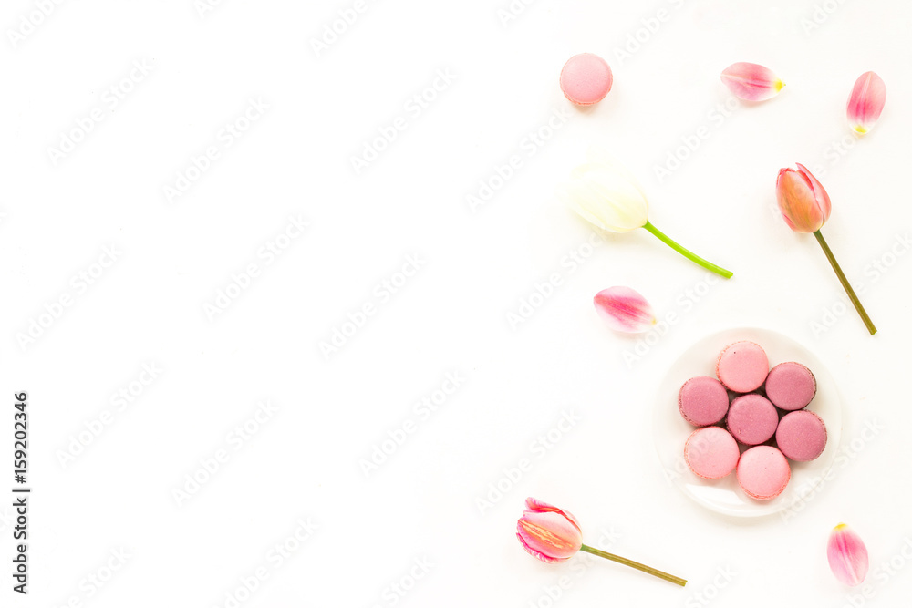Lilac tulip flowers, macaroon cake on white background. Flat lay, top view Lilac tulip flowers, macaroon cake on white background. Flat lay, top view